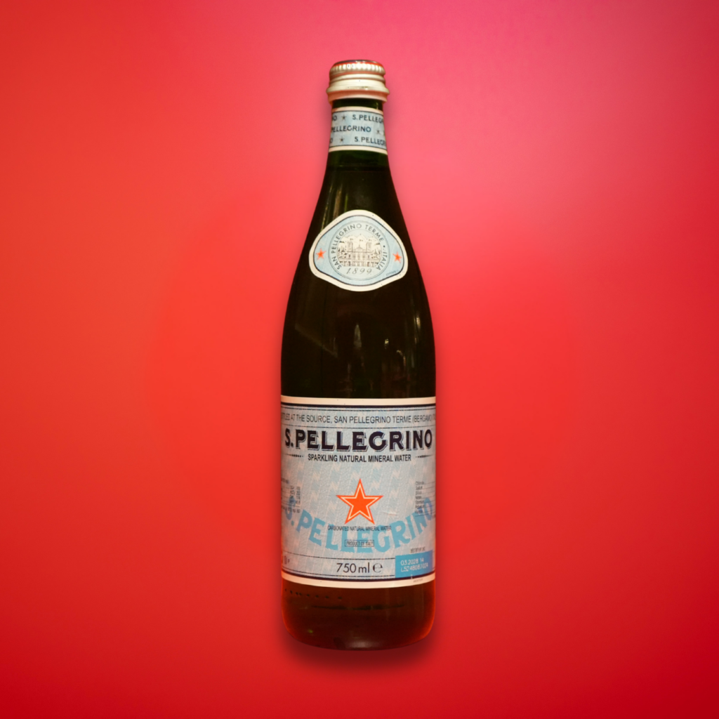 glass san pellegrino bottle on red background