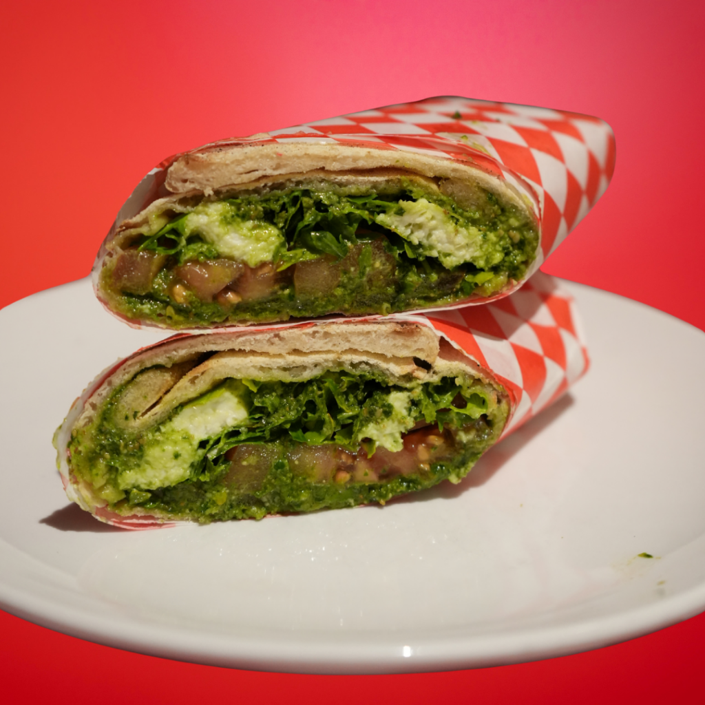 Caprese panuozzo on white plate with red background